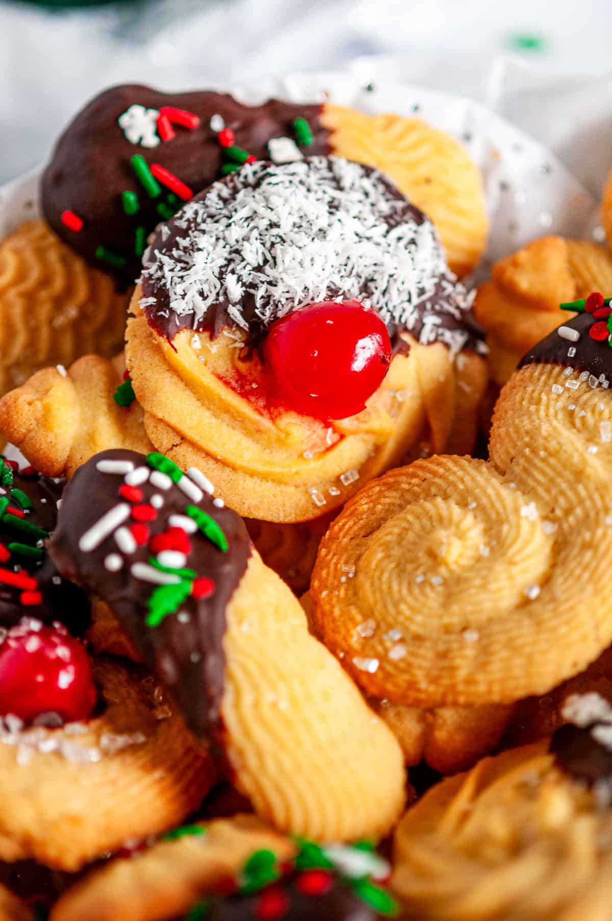 Italian Butter Cookies arranged for Christmas baking with chocolate-dipped cookies, sprinkles, and decorative accents