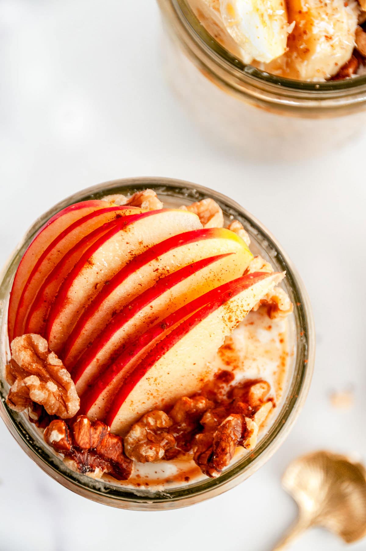 Apple pie overnight oats topped with sliced apples and walnuts