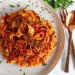 Instant Pot Beef Short Rib Pasta Ragu served over pappardelle with fresh parsley and Parmesan on a white plate overhead.