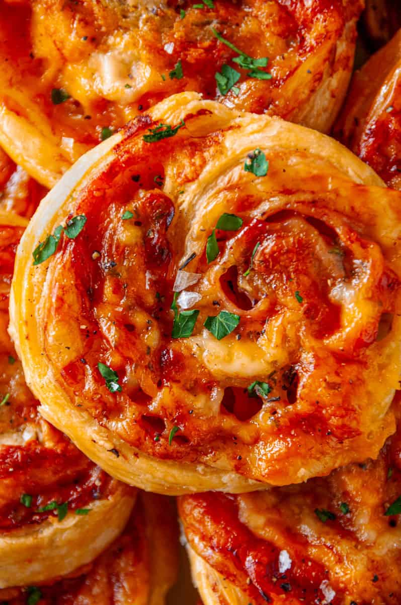 Detailed close-up of a ham and cheese pinwheel highlighting flaky layers and gooey cheese filling