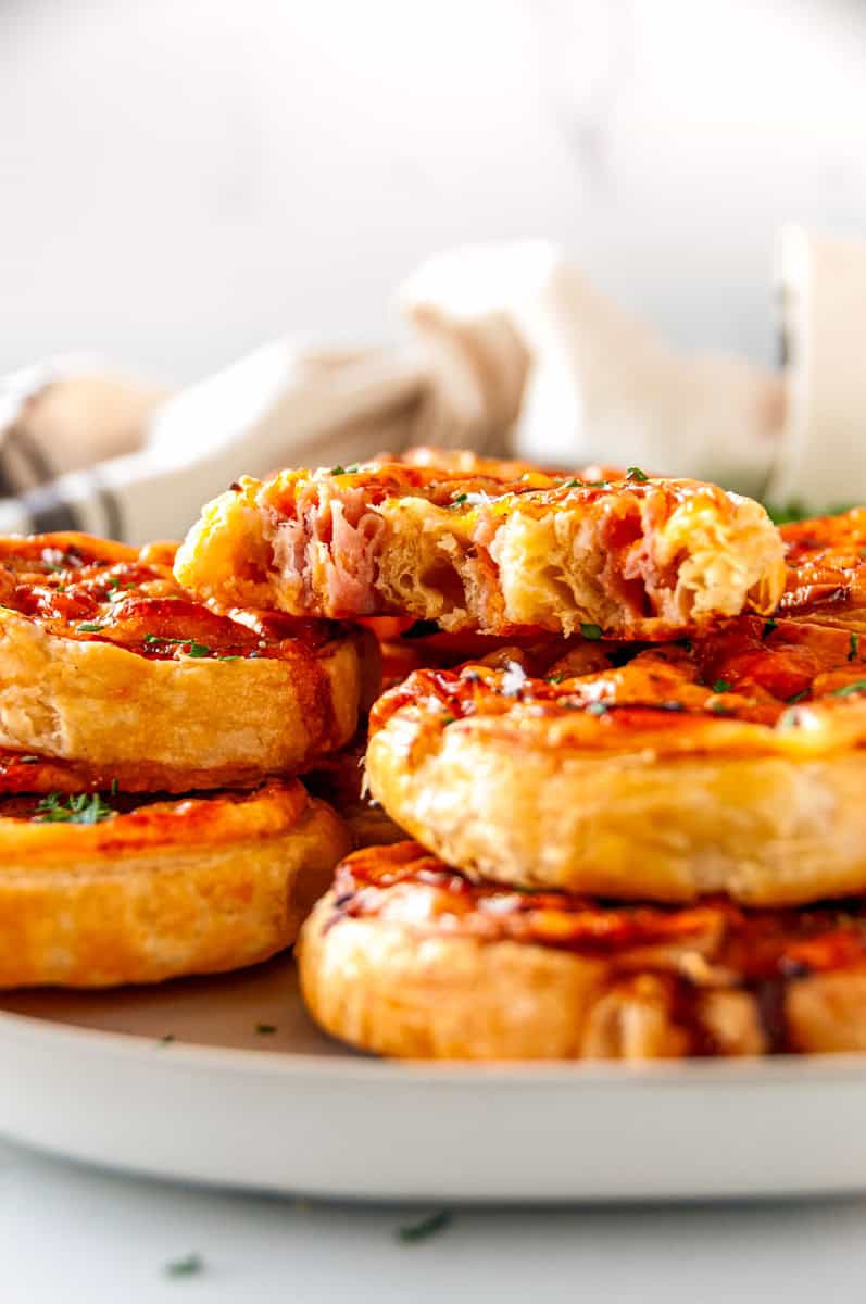 Ham and cheese pinwheels with one sliced open to show the soft interior and layers of ham and cheese